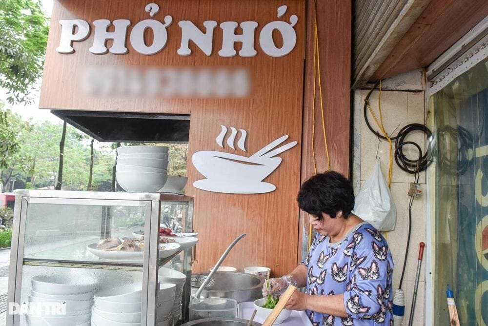 Vietnamese street food vendors preparing fresh pho for breakfast customers in Hanoi
